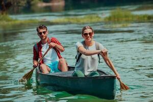 coppia avventuroso esploratore amici siamo canoa nel un' selvaggio fiume circondato di il bellissimo natura foto