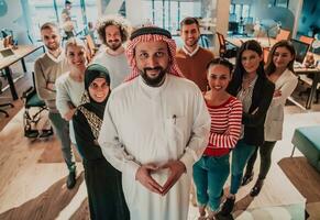 un' diverso gruppo di riuscito attività commerciale persone nel un' moderno bicchiere ufficio In piedi insieme a il superiore con loro arabo capo direttore foto