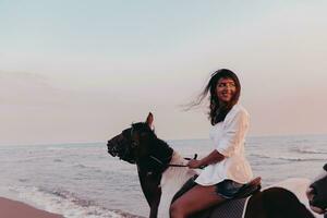 donna nel estate Abiti gode equitazione un' cavallo su un' bellissimo sabbioso spiaggia a tramonto. selettivo messa a fuoco foto