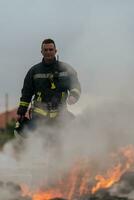ritratto di un' eroico vigile del fuoco nel un' protettivo completo da uomo. pompiere nel fuoco combattente operazione. foto