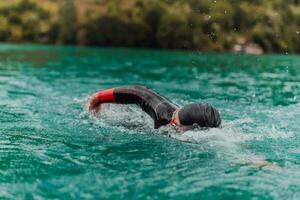 un' triatleta nel un' professionale nuoto completo da uomo treni su il fiume mentre preparazione per olimpico nuoto foto