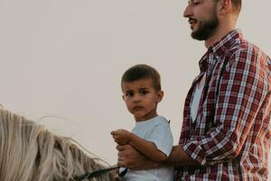 padre e figlio godere equitazione cavalli insieme di il mare. selettivo messa a fuoco foto