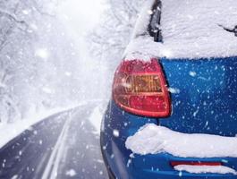 nevicata lungo il percorso. strada forestale con auto in inverno nevoso giorno. foto