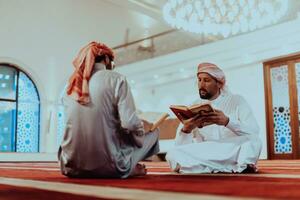 un' gruppo di I musulmani lettura il santo libro di il Corano nel un' moderno moschea durante il musulmano vacanza di Ramadan foto