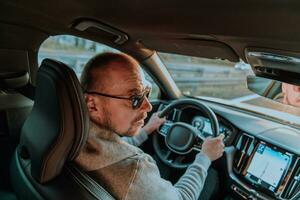 un' uomo con un' occhiali da sole guida un' auto a tramonto. il concetto di auto viaggio foto