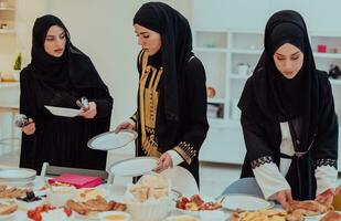 eid mubarak musulmano famiglia avendo iftar cena giovane musulmano ragazze servendo cibo su il tavolo durante Ramadan banchettare mese a casa. il islamico halal mangiare e potabile islamico famiglia foto
