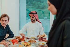 musulmano famiglia avendo iftar cena potabile acqua per rompere festa. mangiare tradizionale cibo durante Ramadan banchettare mese a casa. il islamico halal mangiare e potabile nel moderno casa foto