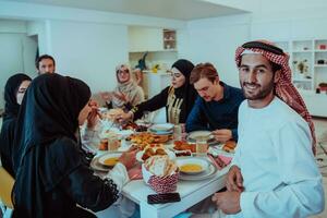 musulmano famiglia avendo iftar cena potabile acqua per rompere festa. mangiare tradizionale cibo durante Ramadan banchettare mese a casa. il islamico halal mangiare e potabile nel moderno casa foto