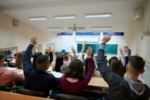 sollevato mani e braccia di grande gruppo di persone nel classe camera foto