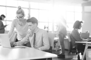 Due attività commerciale persone Lavorando con il computer portatile nel ufficio foto