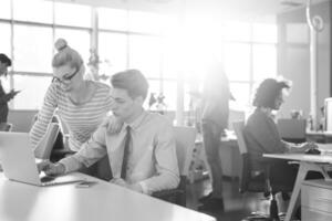 Due attività commerciale persone Lavorando con il computer portatile nel ufficio foto