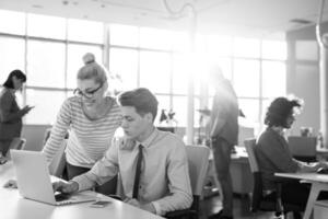 Due attività commerciale persone Lavorando con il computer portatile nel ufficio foto