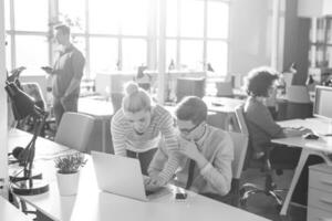 Due attività commerciale persone Lavorando con il computer portatile nel ufficio foto