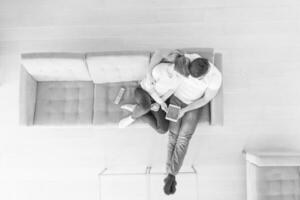 giovane coppia in soggiorno utilizzando tablet vista dall'alto foto