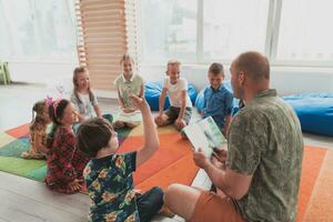 lettura tempo nel elementare scuola o asilo, insegnante lettura un' libro per bambini nel elementare scuola o asilo nido. selettivo messa a fuoco foto