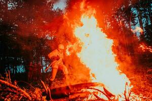 pompiere eroe nel azione Pericolo salto al di sopra di fuoco fiamma per salvare e Salva foto