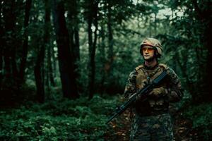 un' moderno guerra soldato su guerra dovere nel denso e pericoloso foresta le zone. pericoloso militare salvare operazioni foto