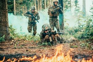 moderno guerra soldati circondato di fuoco combattimento nel denso e pericoloso foresta le zone foto