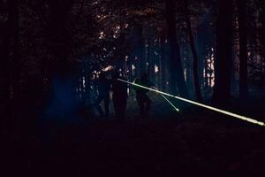 soldati squadra nel azione su notte missione utilizzando laser vista fascio luci militare squadra concetto foto