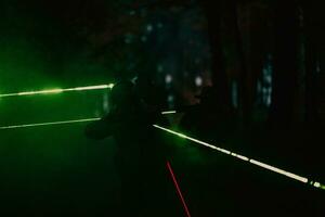 soldati squadra nel azione su notte missione utilizzando laser vista fascio luci militare squadra concetto foto