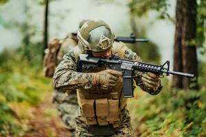 un' gruppo di moderno guerra soldati è combattente un' guerra nel pericoloso a distanza foresta le zone. un' gruppo di soldati è combattente su il nemico linea con moderno Armi. il concetto di guerra e militare conflitti foto