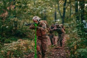 un' gruppo di moderno guerra soldati è combattente un' guerra nel pericoloso a distanza foresta le zone. un' gruppo di soldati è combattente su il nemico linea con moderno Armi. il concetto di guerra e militare conflitti foto