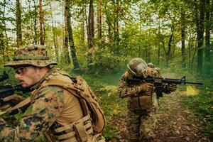 un' gruppo di moderno guerra soldati è combattente un' guerra nel pericoloso a distanza foresta le zone. un' gruppo di soldati è combattente su il nemico linea con moderno Armi. il concetto di guerra e militare conflitti foto