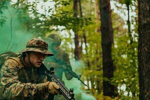 un' gruppo di moderno guerra soldati è combattente un' guerra nel pericoloso a distanza foresta le zone. un' gruppo di soldati è combattente su il nemico linea con moderno Armi. il concetto di guerra e militare conflitti foto