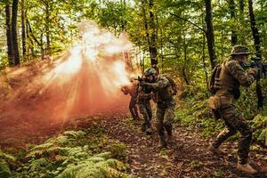 un' gruppo di moderno guerra soldati è combattente un' guerra nel pericoloso a distanza foresta le zone. un' gruppo di soldati è combattente su il nemico linea con moderno Armi. il concetto di guerra e militare conflitti foto