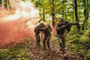 un' gruppo di moderno guerra soldati è combattente un' guerra nel pericoloso a distanza foresta le zone. un' gruppo di soldati è combattente su il nemico linea con moderno Armi. il concetto di guerra e militare conflitti foto