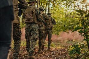 un' gruppo di moderno guerra soldati è combattente un' guerra nel pericoloso a distanza foresta le zone. un' gruppo di soldati è combattente su il nemico linea con moderno Armi. il concetto di guerra e militare conflitti foto