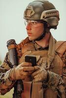 soldato utilizzando smartphone per contatto famiglia o fidanzata comunicazione e nostalgia concetto foto