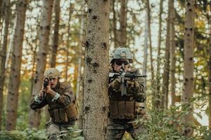 un' gruppo di moderno guerra soldati è combattente un' guerra nel pericoloso a distanza foresta le zone. un' gruppo di soldati è combattente su il nemico linea con moderno Armi. il concetto di guerra e militare conflitti foto