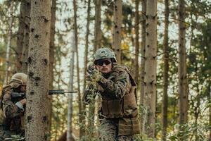 un' gruppo di moderno guerra soldati è combattente un' guerra nel pericoloso a distanza foresta le zone. un' gruppo di soldati è combattente su il nemico linea con moderno Armi. il concetto di guerra e militare conflitti foto