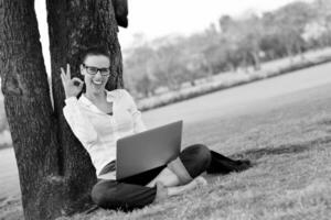 donna con il computer portatile nel parco foto