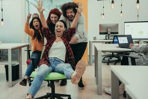 squadra edificio e ufficio divertimento. giovane allegro uomini d'affari nel inteligente casuale indossare avendo divertimento mentre da corsa su ufficio sedie e sorridente. foto