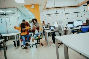 squadra edificio e ufficio divertimento. giovane allegro uomini d'affari nel inteligente casuale indossare avendo divertimento mentre da corsa su ufficio sedie e sorridente. foto