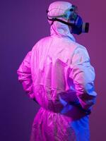 coronavirus covid-19 pandemia. medico scienziato indossare protettivo biologico completo da uomo e maschera dovuto per globale assistenza sanitaria epidemico avvertimento e Pericolo sfondo nel blu e rosa neon luci sfondo. foto