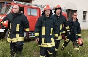 gruppo di fuoco combattenti in piedi fiducioso dopo un' bene fatto salvare operazione. pompiere pronto per emergenza servizio. foto