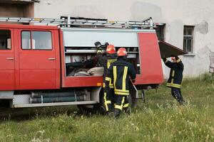 gruppo di fuoco combattenti in piedi fiducioso dopo un' bene fatto salvare operazione. pompiere pronto per emergenza servizio. foto