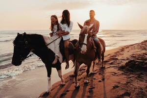 il famiglia spende tempo con loro bambini mentre equitazione cavalli insieme su un' sabbioso spiaggia. selettivo messa a fuoco foto