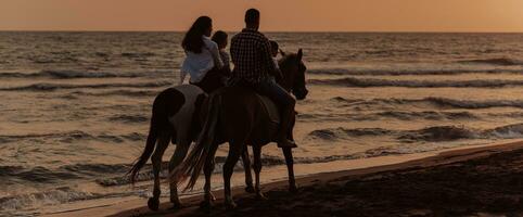 il famiglia spende tempo con loro bambini mentre equitazione cavalli insieme su un' sabbioso spiaggia. selettivo messa a fuoco foto