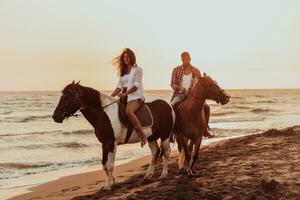 un' amorevole coppia nel estate Abiti equitazione un' cavallo su un' sabbioso spiaggia a tramonto. mare e tramonto nel il sfondo. selettivo messa a fuoco foto