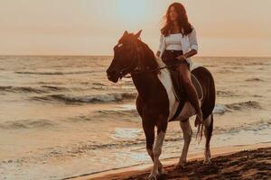 donna nel estate Abiti gode equitazione un' cavallo su un' bellissimo sabbioso spiaggia a tramonto. selettivo messa a fuoco foto