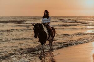 donna nel estate Abiti gode equitazione un' cavallo su un' bellissimo sabbioso spiaggia a tramonto. selettivo messa a fuoco foto