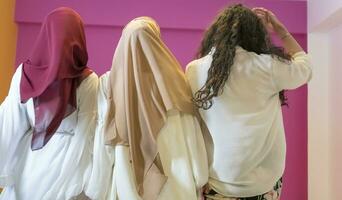 gruppo ritratto di bellissimo musulmano donne Due di loro nel alla moda vestito con hijab isolato su rosa sfondo che rappresentano moderno Islam moda e Ramadan kareem concetto foto