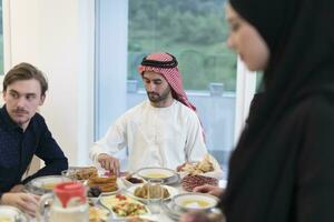 eid mubarak musulmano famiglia avendo iftar cena potabile acqua per rompere festa. mangiare tradizionale cibo durante Ramadan banchettare mese a casa. il islamico halal mangiare e potabile a moderno occidentale isla foto