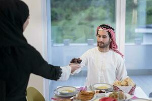 moderno multietnico musulmano famiglia condivisione un' ciotola di date mentre godendo iftar cena insieme durante un' Ramadan festa a casa foto