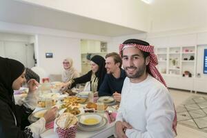 giovane arabo uomo avendo iftar cena con musulmano famiglia mangiare tradizionale cibo durante Ramadan banchettare mese a casa. il islamico halal mangiare e potabile islamico famiglia foto