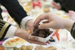 moderno multietnico musulmano famiglia condivisione un' ciotola di date mentre godendo iftar cena insieme durante un' Ramadan festa a casa foto